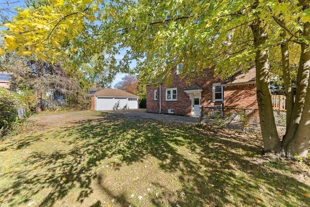1164 Sumner Avenue Springfield, MA 01118 - Photo 4 of 30 a front view of a house with a yard and large trees