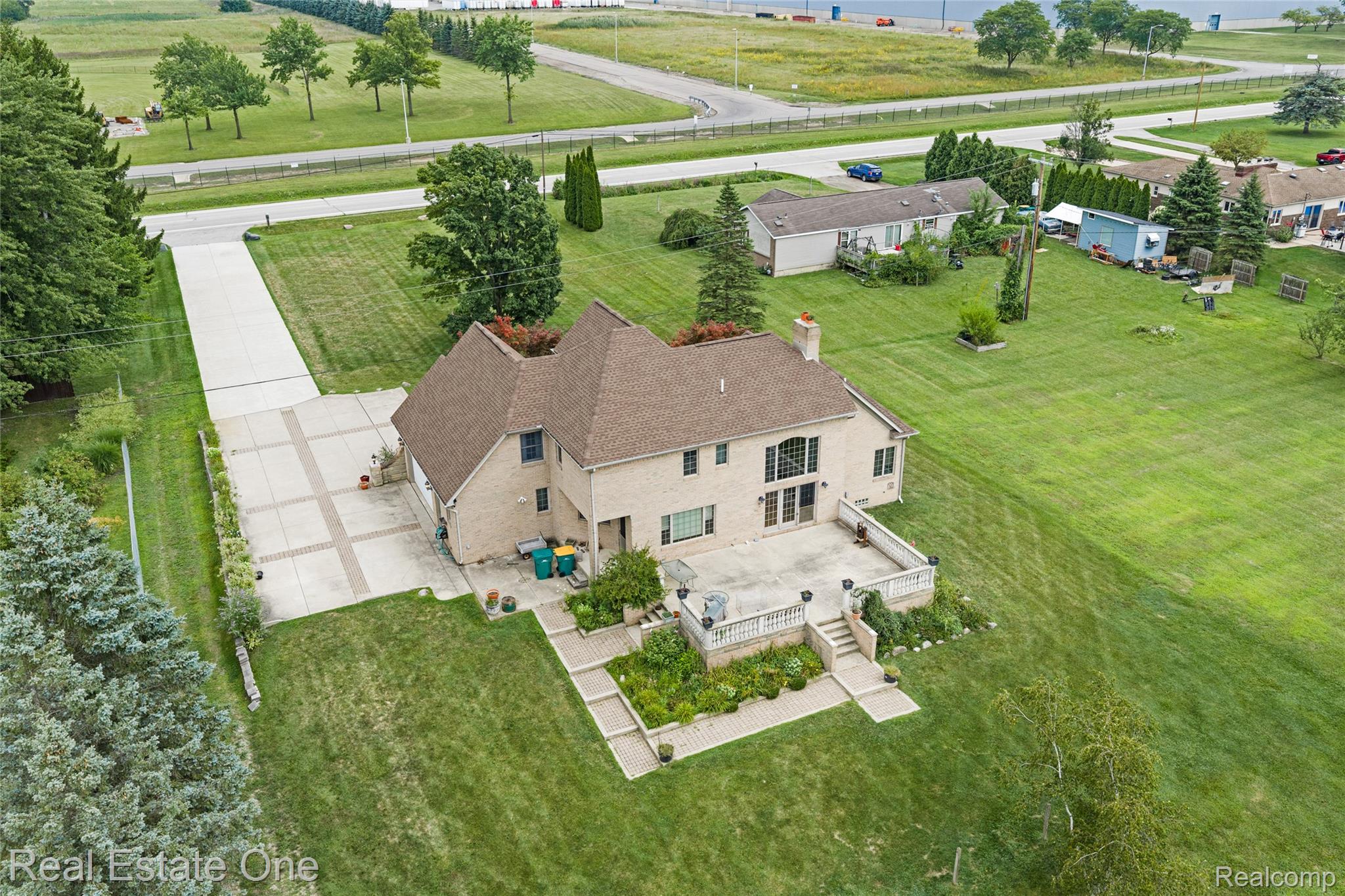 17268 Beech Daly Road Romulus, MI 48174 - Photo 13 of 60 Multi-story residence featuring a large rear patio, expansive lawn, and mature landscaping