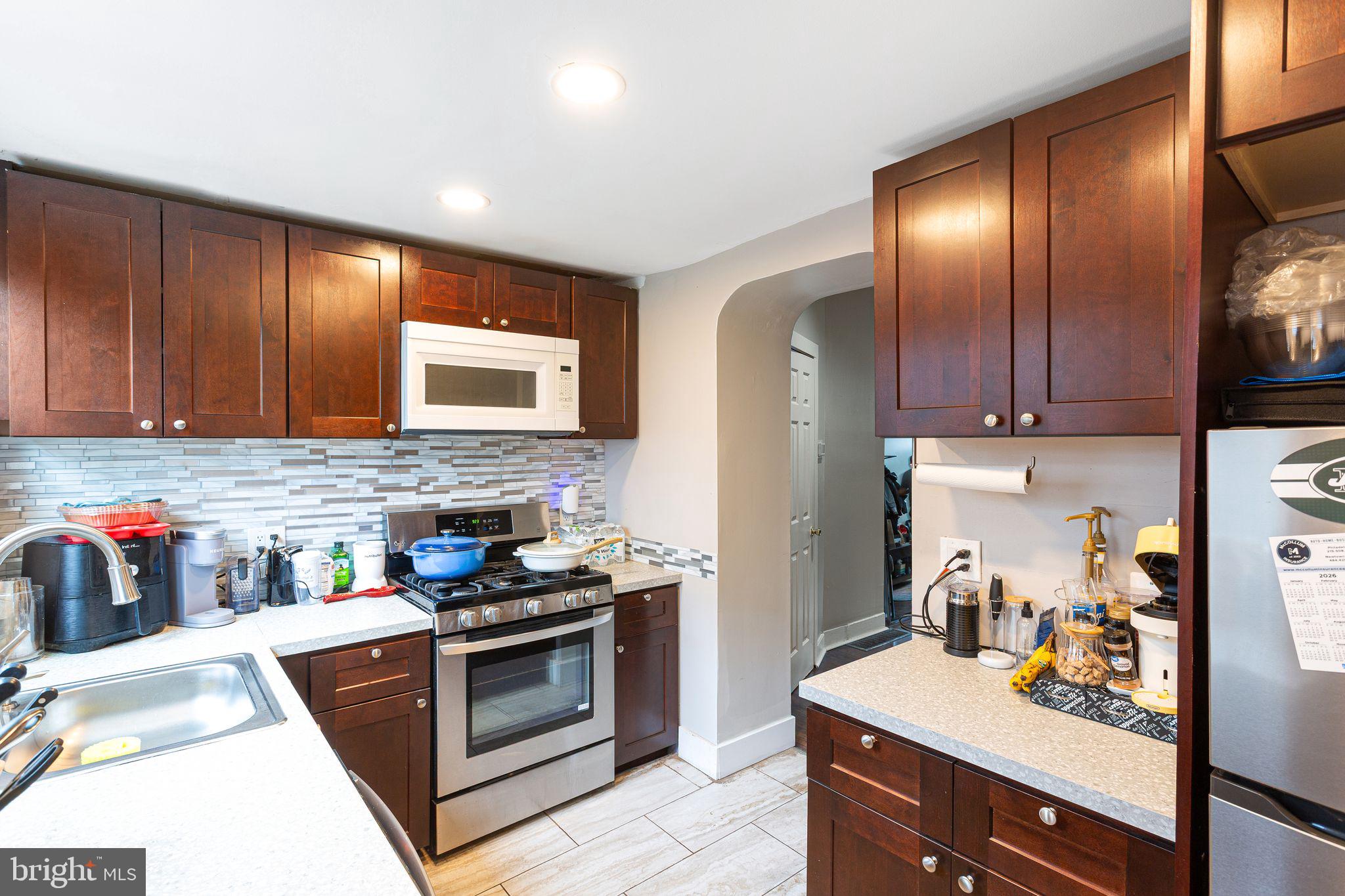 140 Wendover Street Philadelphia, PA 19127 - Photo 4 of 16 a kitchen with stainless steel appliances granite countertop wooden cabinets sink and stove top oven