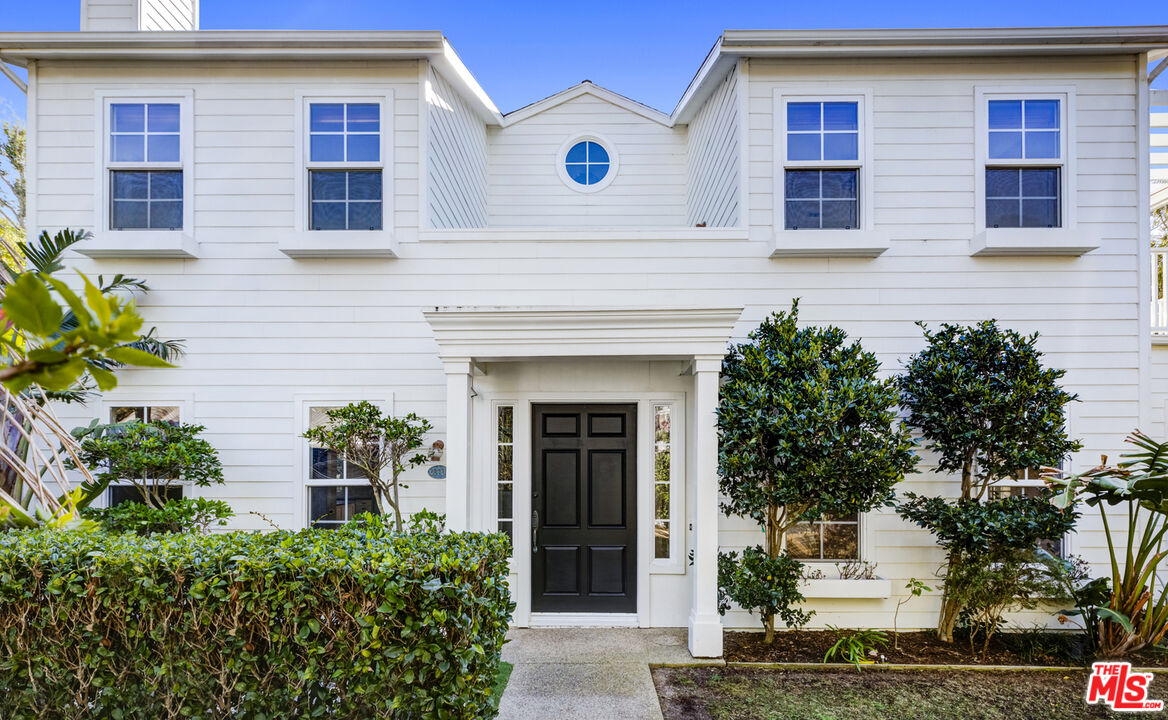 a view of a house with a window and potted plants