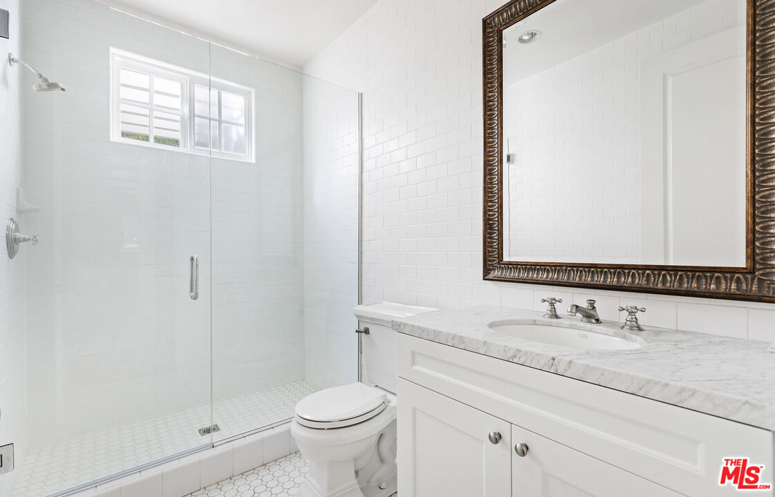 28930 Hampton Place Malibu, CA 90265 - Photo 49 of 55 a bathroom with a granite countertop sink a toilet and a mirror