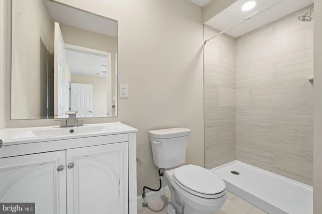 a bathroom with a toilet a sink a mirror and a shower