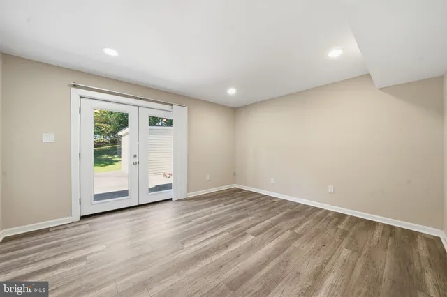 an empty room with wooden floor and window