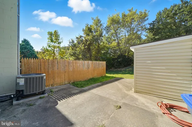 a view of a backyard with a large tree and wooden fence