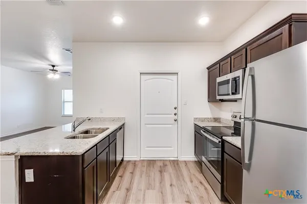a kitchen with a refrigerator stove and sink