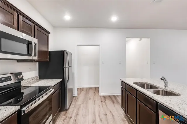 a kitchen with a sink stove and refrigerator