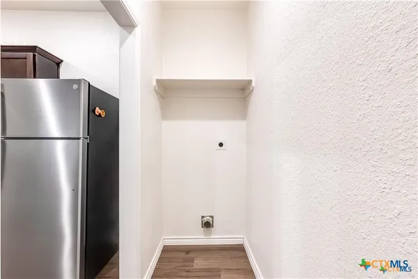 a view of a refrigerator in kitchen and utility room