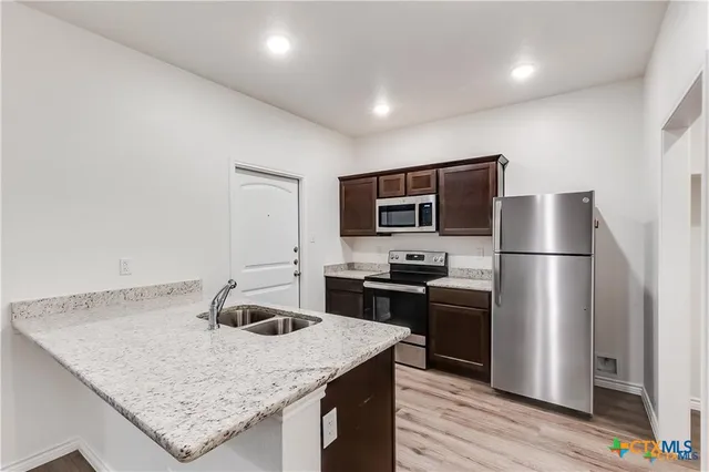 a kitchen with a center island and stainless steel appliances