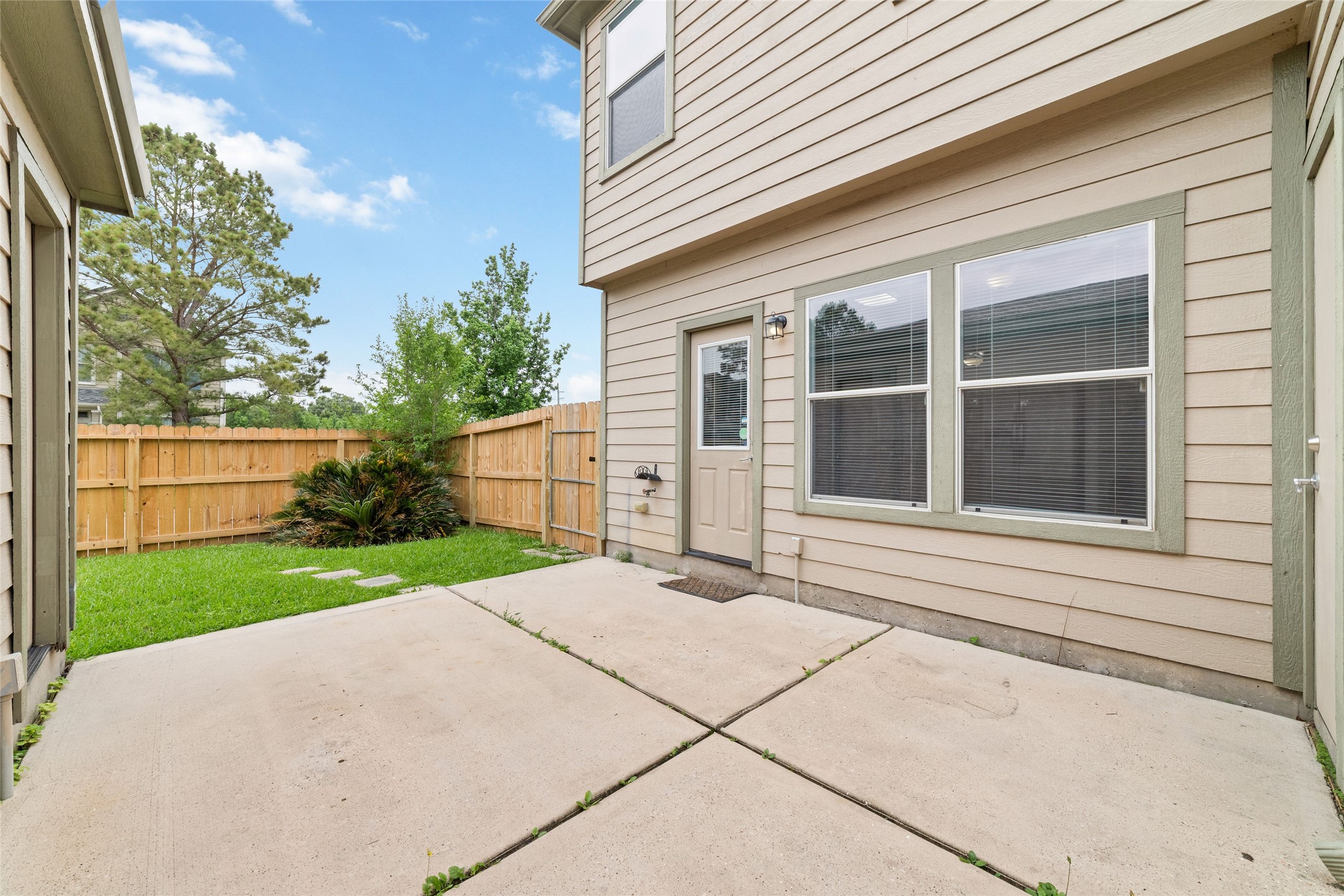 23602 Youpon Lake Lane Spring, TX 77373 - Photo 18 of 21 Cozy backyard patio with easy access to the home and detached garage, creating a great space for relaxing or entertaining outdoors.