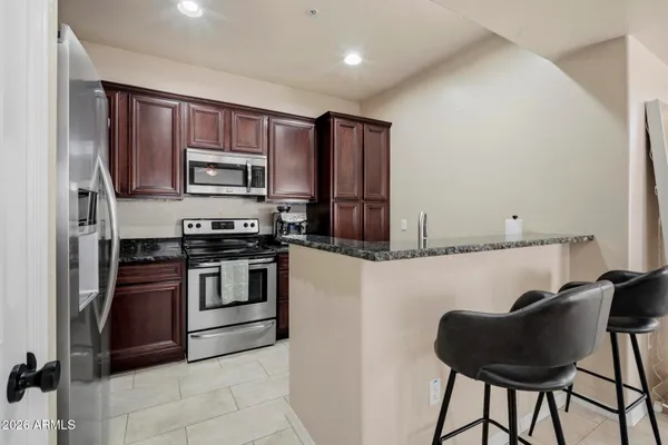 a kitchen with stainless steel appliances granite countertop a refrigerator and a stove top oven