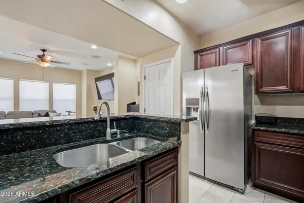 a kitchen with granite countertop a sink cabinets and stainless steel appliances