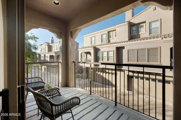 a view of a balcony with wooden floor and iron fence