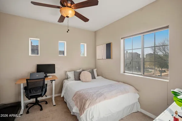 a bedroom with a bed a desk and a chandelier