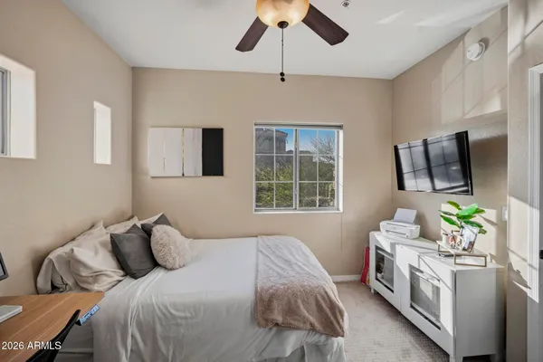 a bedroom with a bed potted plant on dresser and a chandelier
