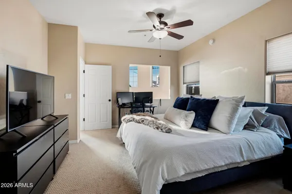 a spacious bedroom with a bed and a flat screen television