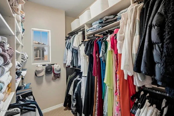 a view of walk in closet with clothes and shoes