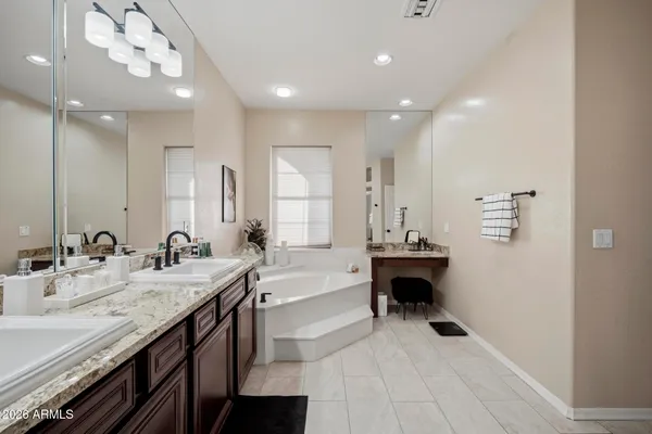 a large bathroom with a double vanity sink a mirror and a bathtub