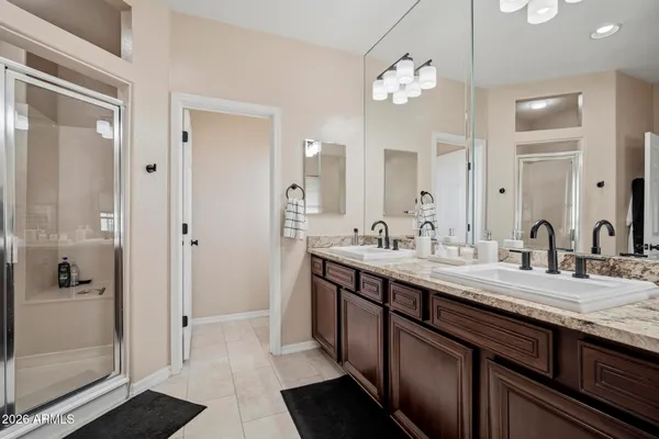a bathroom with a granite countertop sink a large mirror and a shower