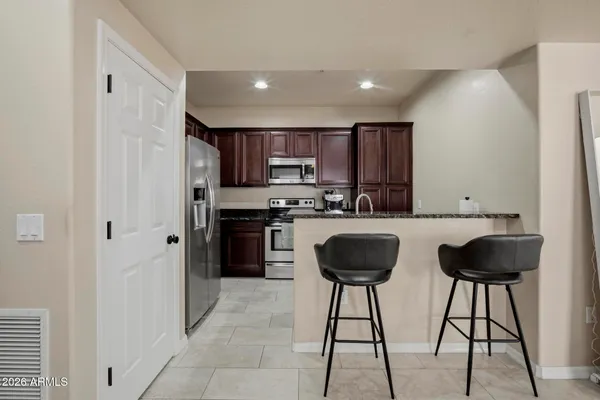 a kitchen with stainless steel appliances granite countertop a refrigerator and a stove top oven