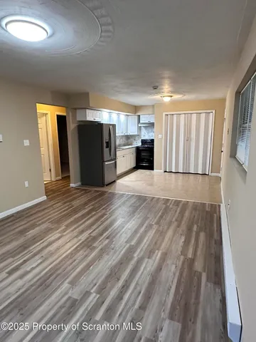 a view of a kitchen with wooden floor and kitchen space