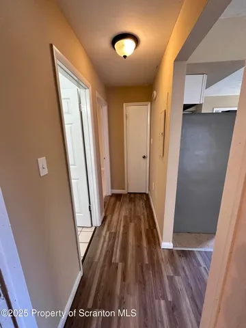 a view of a room with a ceiling fan and carpet