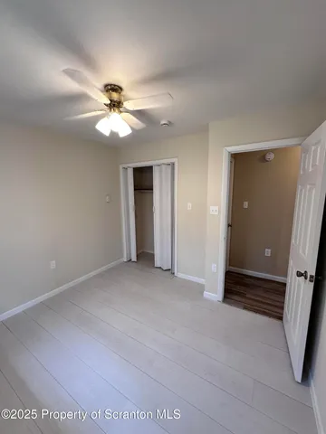 an empty room with a window and a ceiling fan