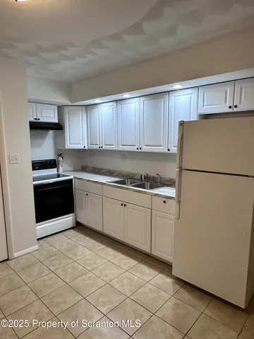 a kitchen with cabinets and white appliances