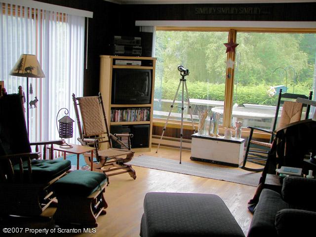 2 Rr Union Dale, PA 18470 - Photo 10 of 15 a living room with furniture a flat screen tv and a floor to ceiling window
