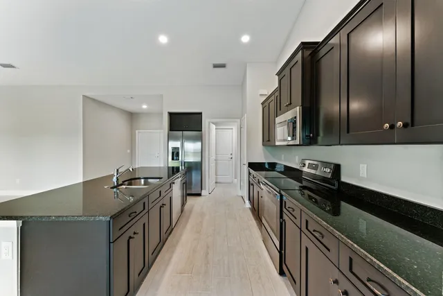 a kitchen with stainless steel appliances a sink stove top oven and cabinets