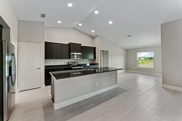 a kitchen with stainless steel appliances a stove a microwave and a sink