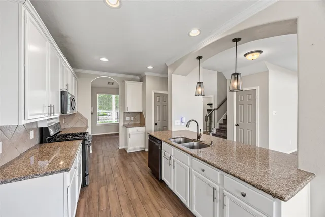 a kitchen with stainless steel appliances granite countertop a sink stove and refrigerator