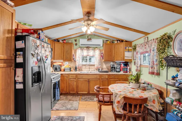 a kitchen with stainless steel appliances kitchen island granite countertop a refrigerator and a dining table