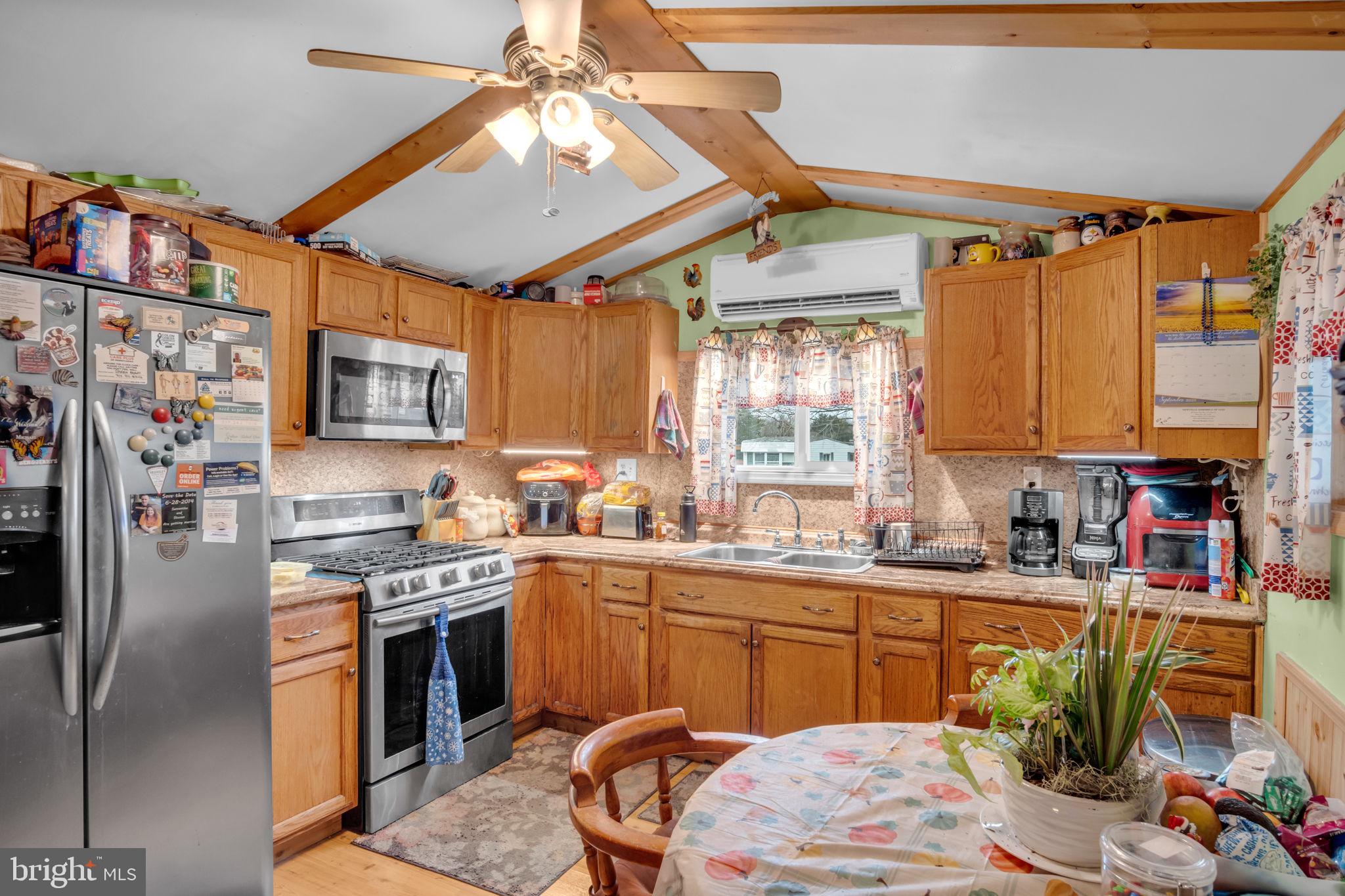 63 Big Spring Terrace Newville, PA 17241 - Photo 4 of 23 a kitchen with stainless steel appliances granite countertop a sink dishwasher a stove a refrigerator and a dining table with wooden floor