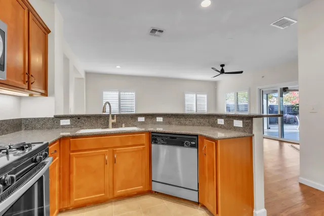 a kitchen with granite countertop a sink cabinets and a wooden floor