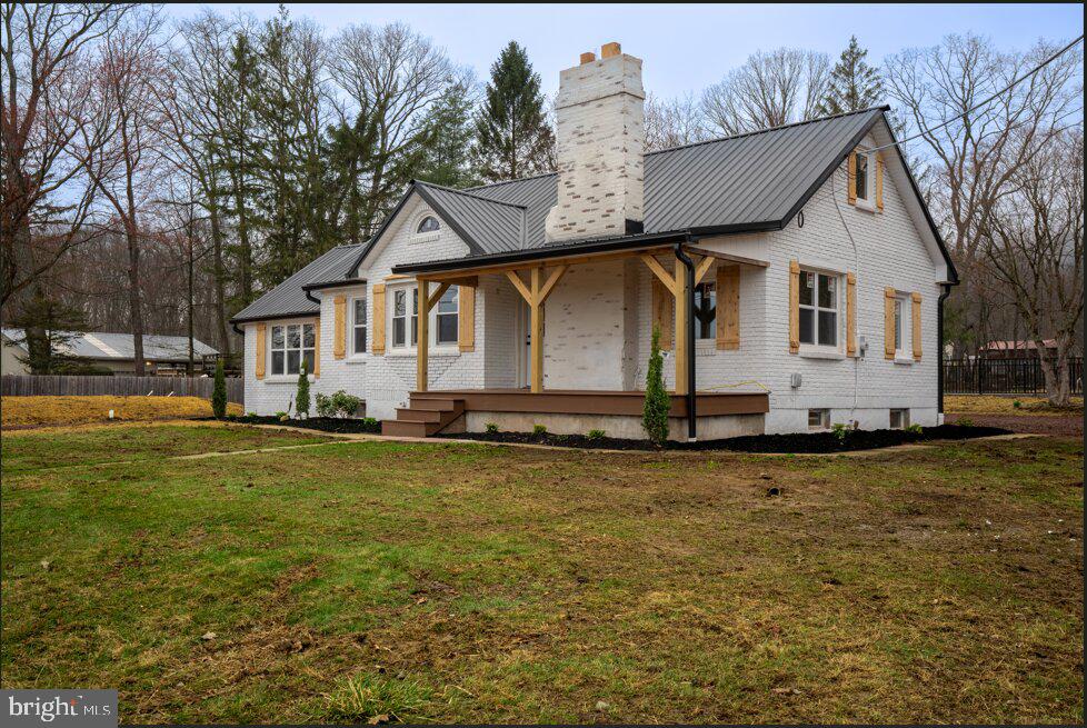 a front view of house with yard and trees in the background