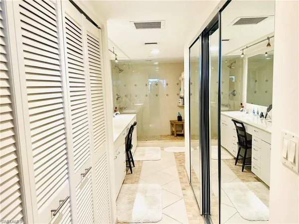 a bathroom with a double vanity sink mirror and shower