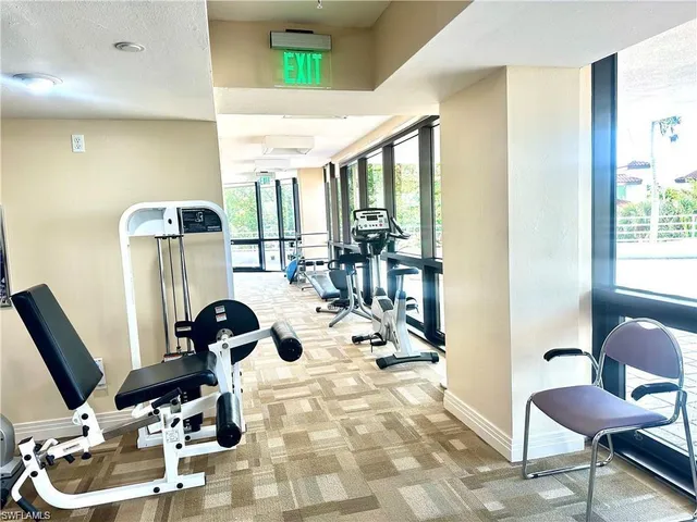 a view of a patio with couches table and chairs under an umbrella