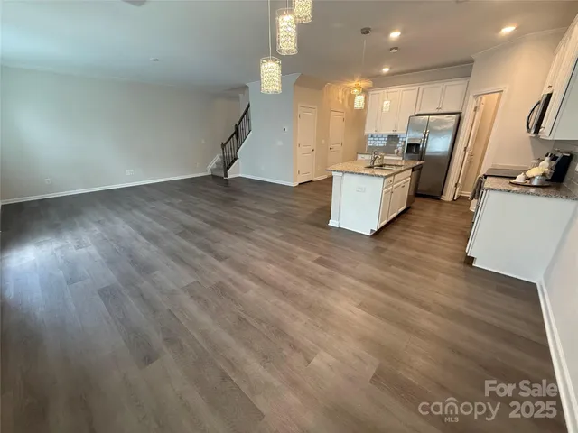 a view of a kitchen with wooden floor and white appliances