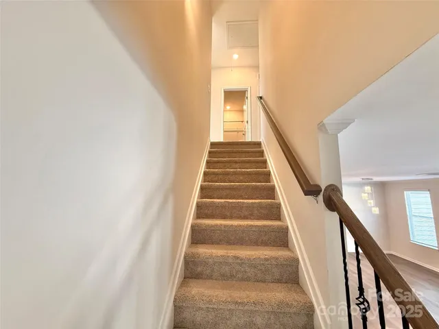 a view of staircase with wooden floor and white walls