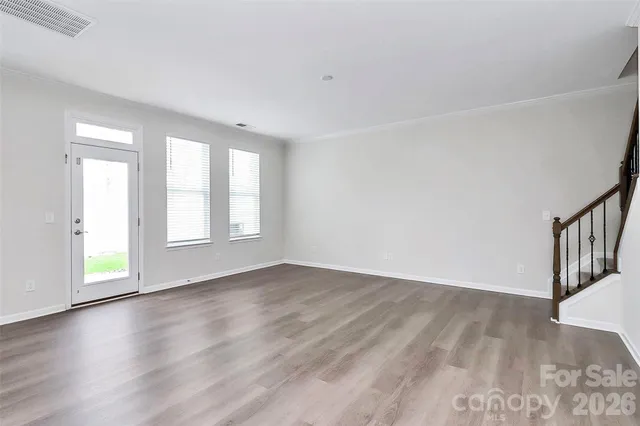 a kitchen with stainless steel appliances a sink stove refrigerator and white cabinets with wooden floor