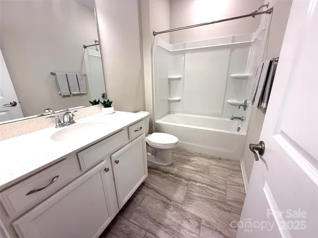 a bathroom with a sink a toilet a mirror and shower