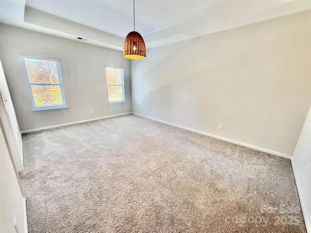 en empty room with windows and ceiling fan