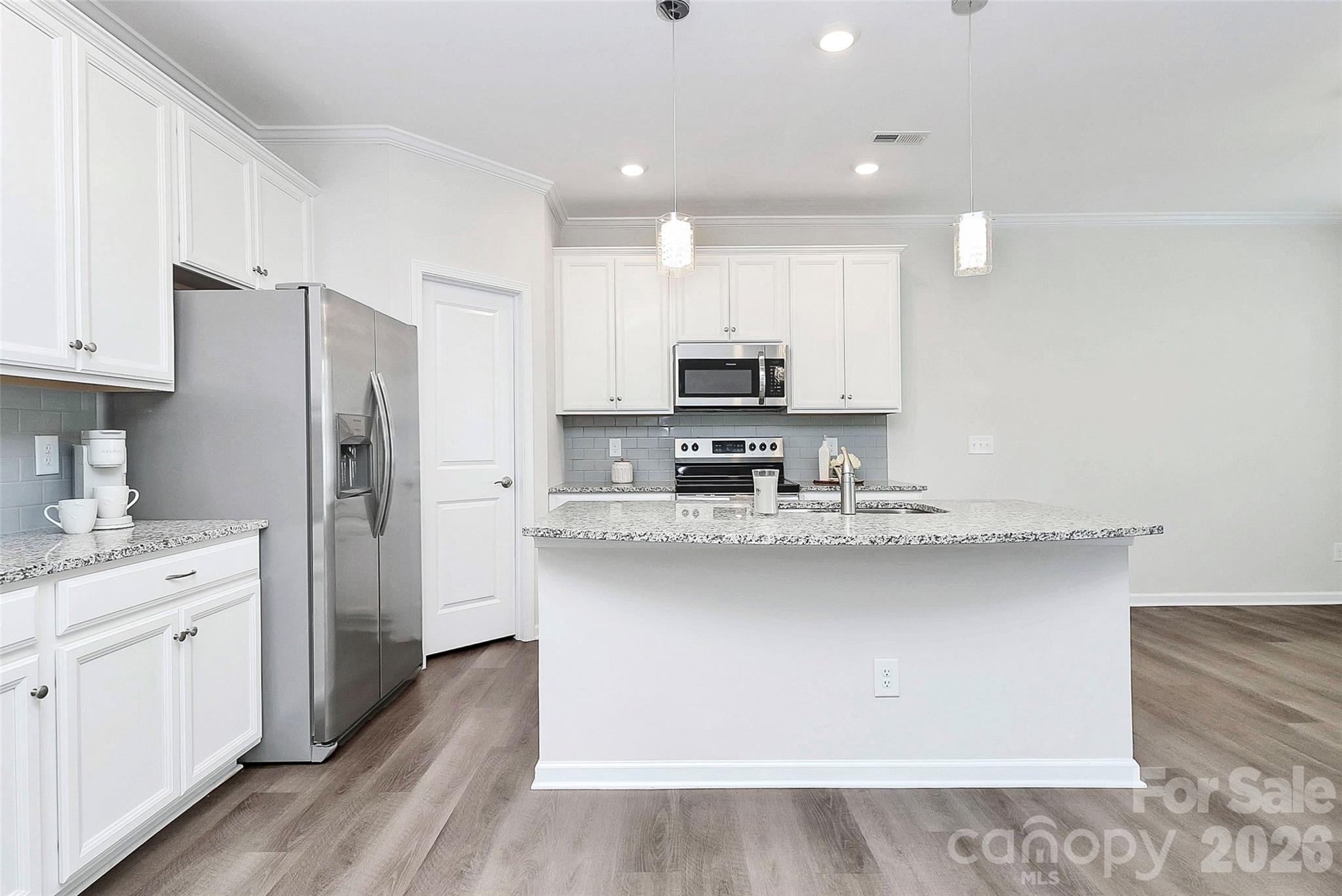769 River Park Road Belmont, NC 28012 - Photo 22 of 41 a kitchen with stainless steel appliances a sink stove refrigerator and white cabinets with wooden floor