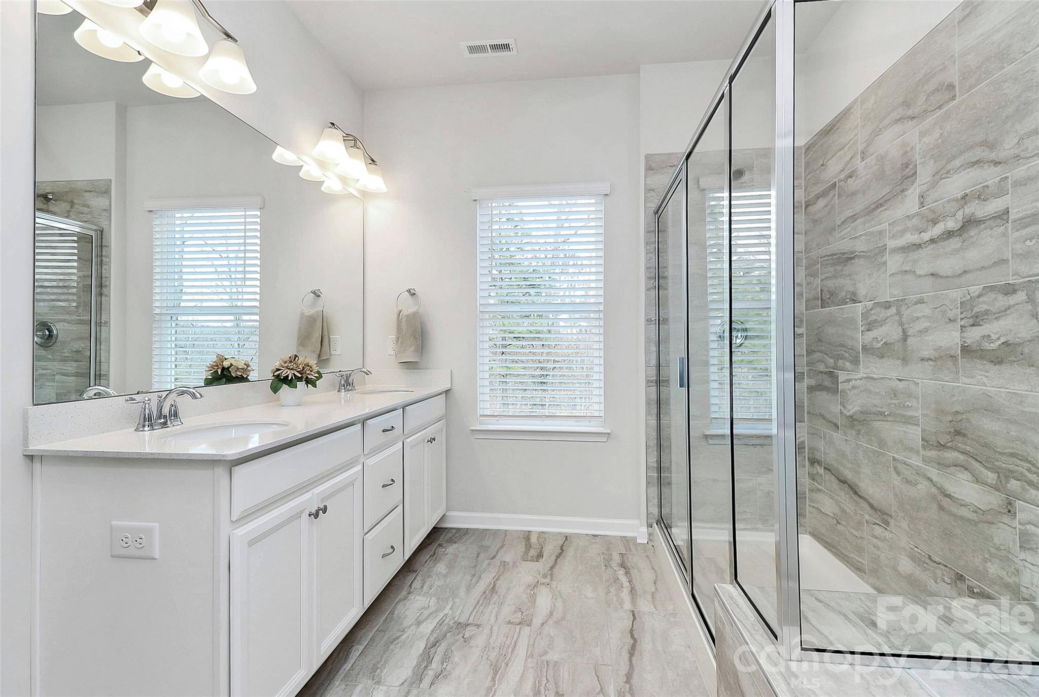 769 River Park Road Belmont, NC 28012 - Photo 25 of 41 a bathroom with a double vanity sink a large mirror and shower