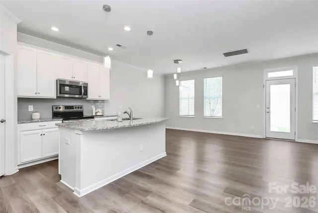 a kitchen with stainless steel appliances a refrigerator sink and cabinets