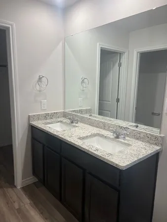 a bathroom with a granite countertop sink and a mirror