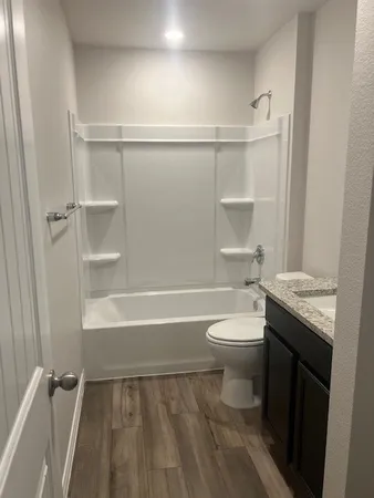 a bathroom with a granite countertop sink toilet and shower