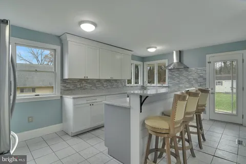 a kitchen with a table chairs sink and cabinets