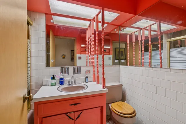 a bathroom with a sink a toilet and mirror