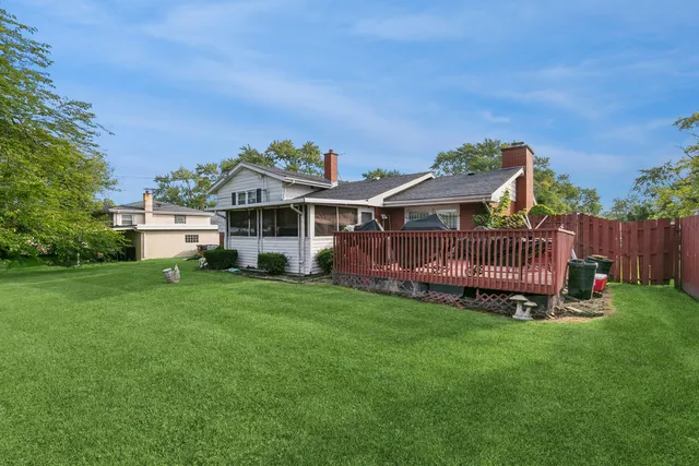 a view of a house with a yard and deck